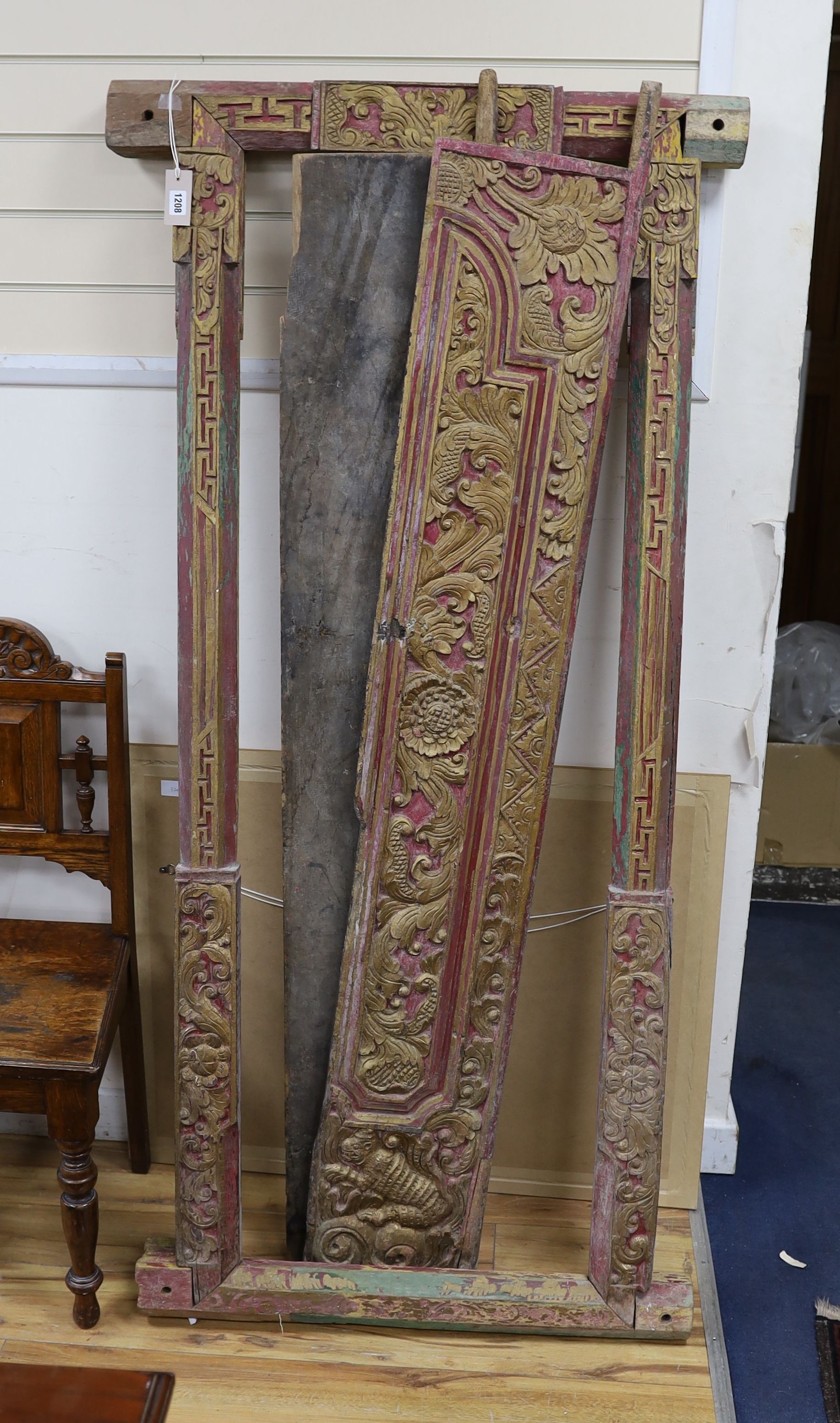 A Balinese carved giltwood door and frame, painted and gilded, width 83cm, height 174cm